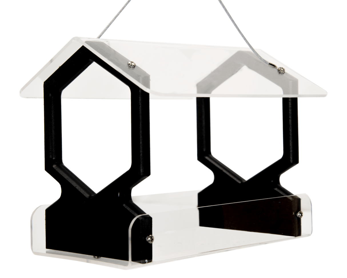 Product shot of an acrylic and black plastic bird feeder with a house-shaped roof featuring hexagonal details and clear acrylic sides hanging from a thin wire