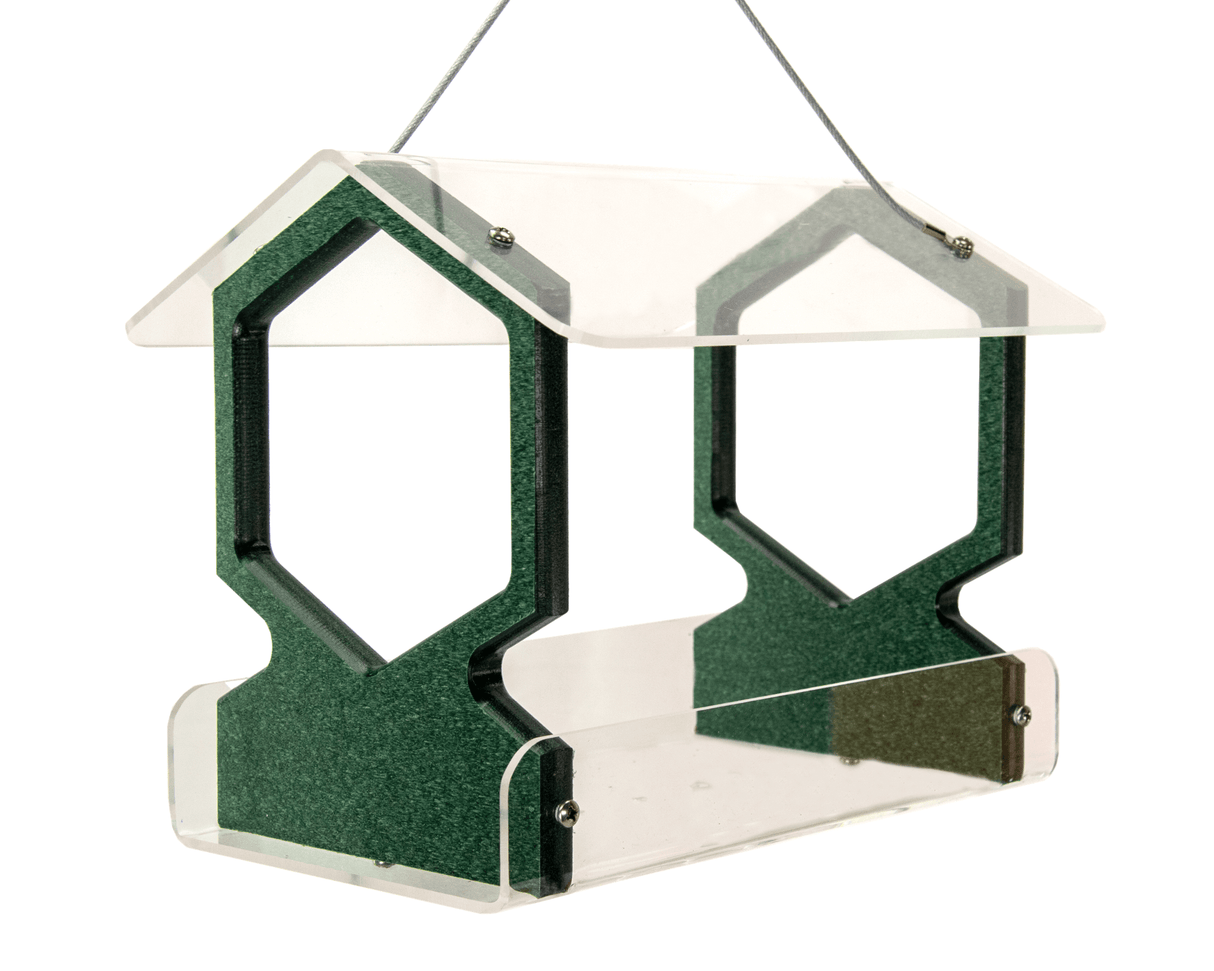 Acrylic and composite bird feeder with a clear acrylic roof and dark green hexagonal perches hanging against a white background featuring metallic screws and a textured surface