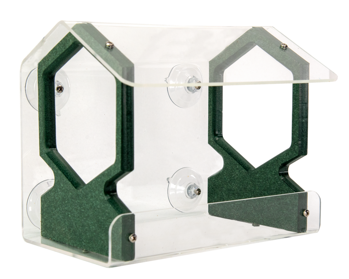 Product shot of a clear acrylic and dark green recycled plastic bird feeder featuring suction cups and hexagon shaped perches.