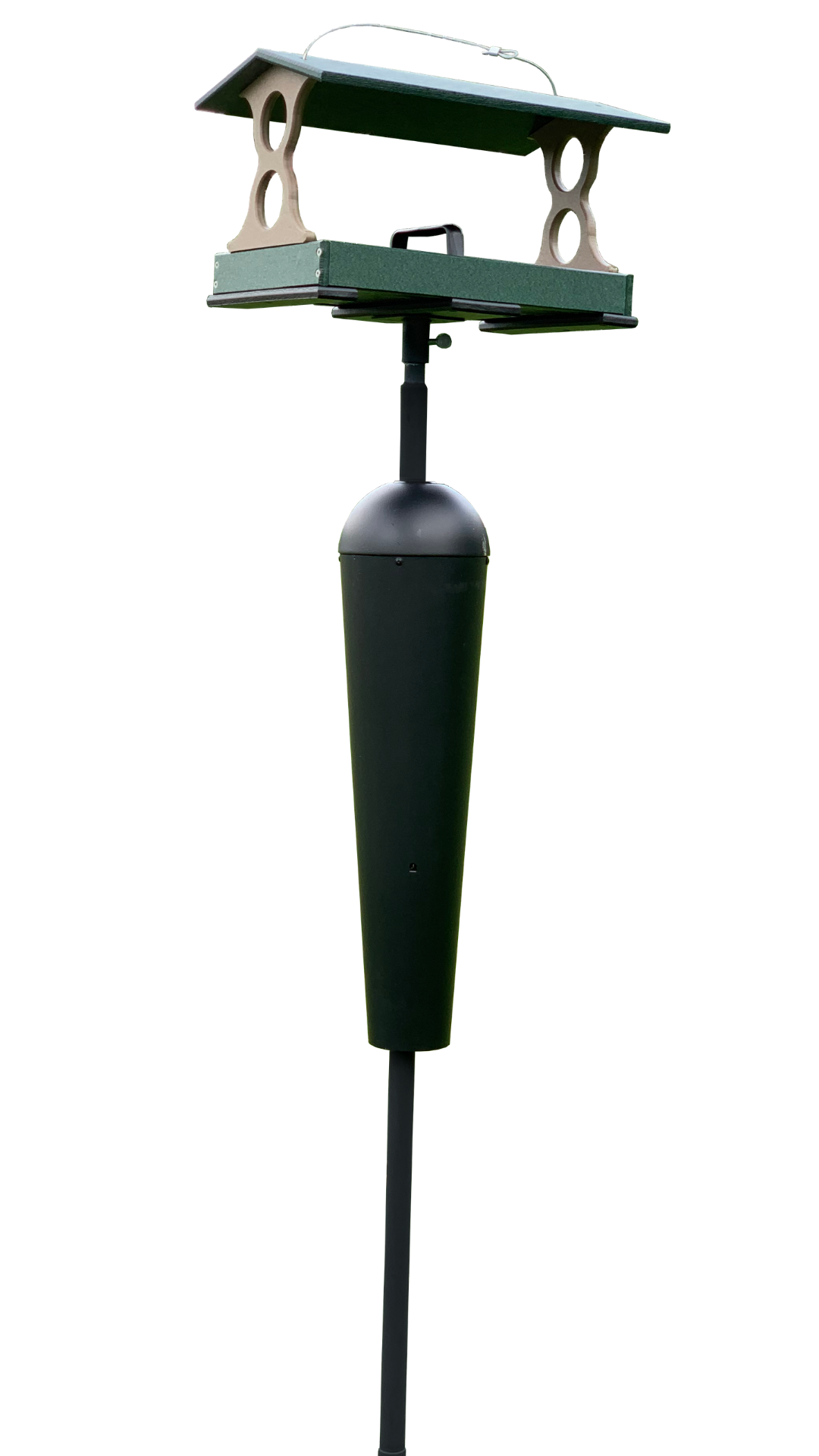 Photograph of a green and brown plastic bird feeder with a black pole and a squirrel baffle featuring a sloped roof and decorative cutouts against a white background