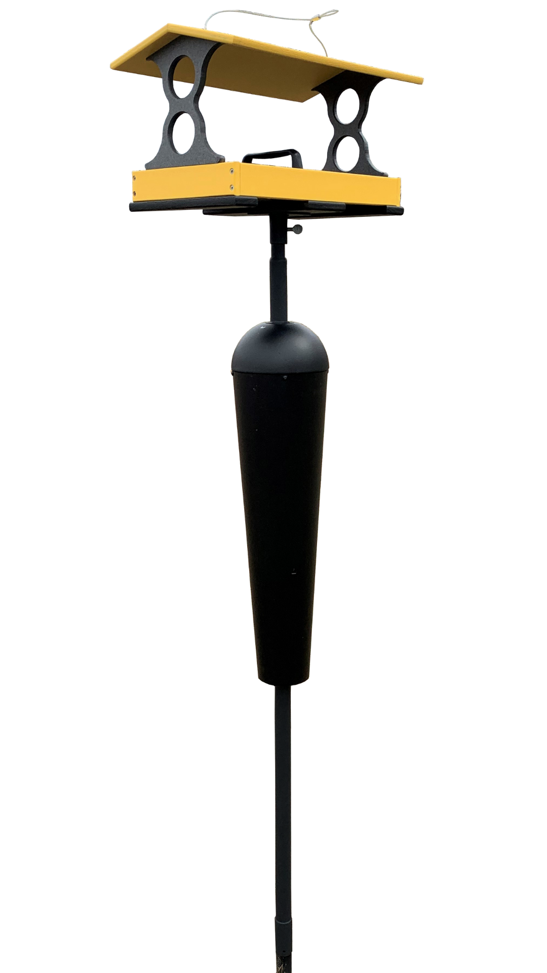 A yellow and black metal bird feeder on a tall post with a protective cone features a double tray design and a weatherproof roof.