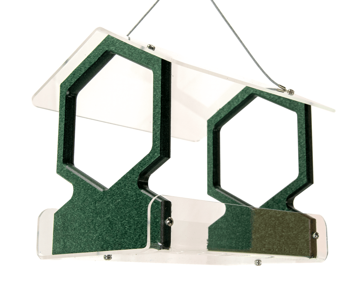 Plastic and acrylic bird feeder with hexagonal openings and a clear acrylic roof showing dark green accents and silver hardware hanging against a white background