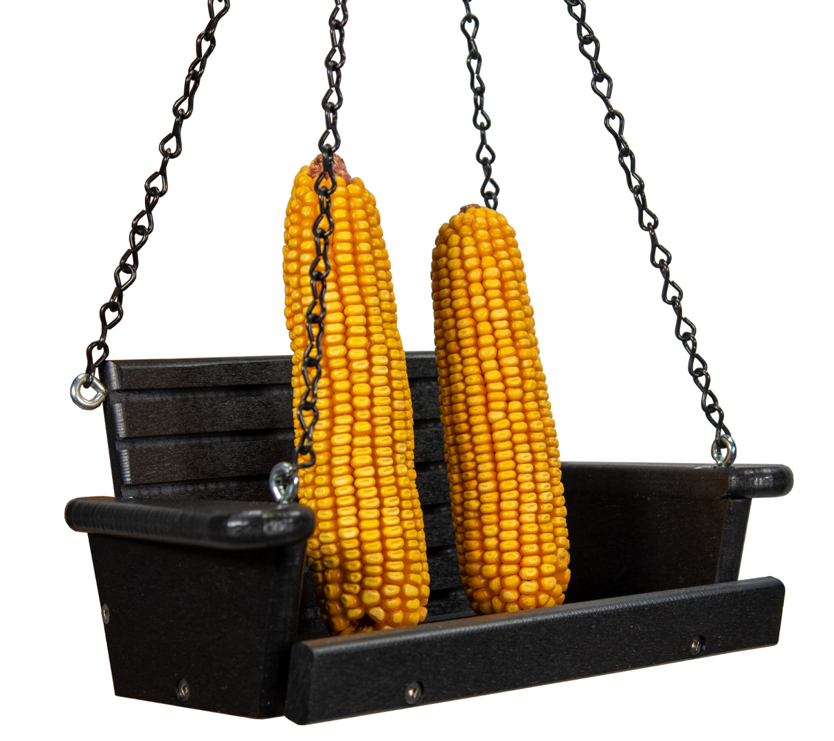 Photograph of two ears of bright yellow corn hanging from black chains on a miniature black wooden swing seat