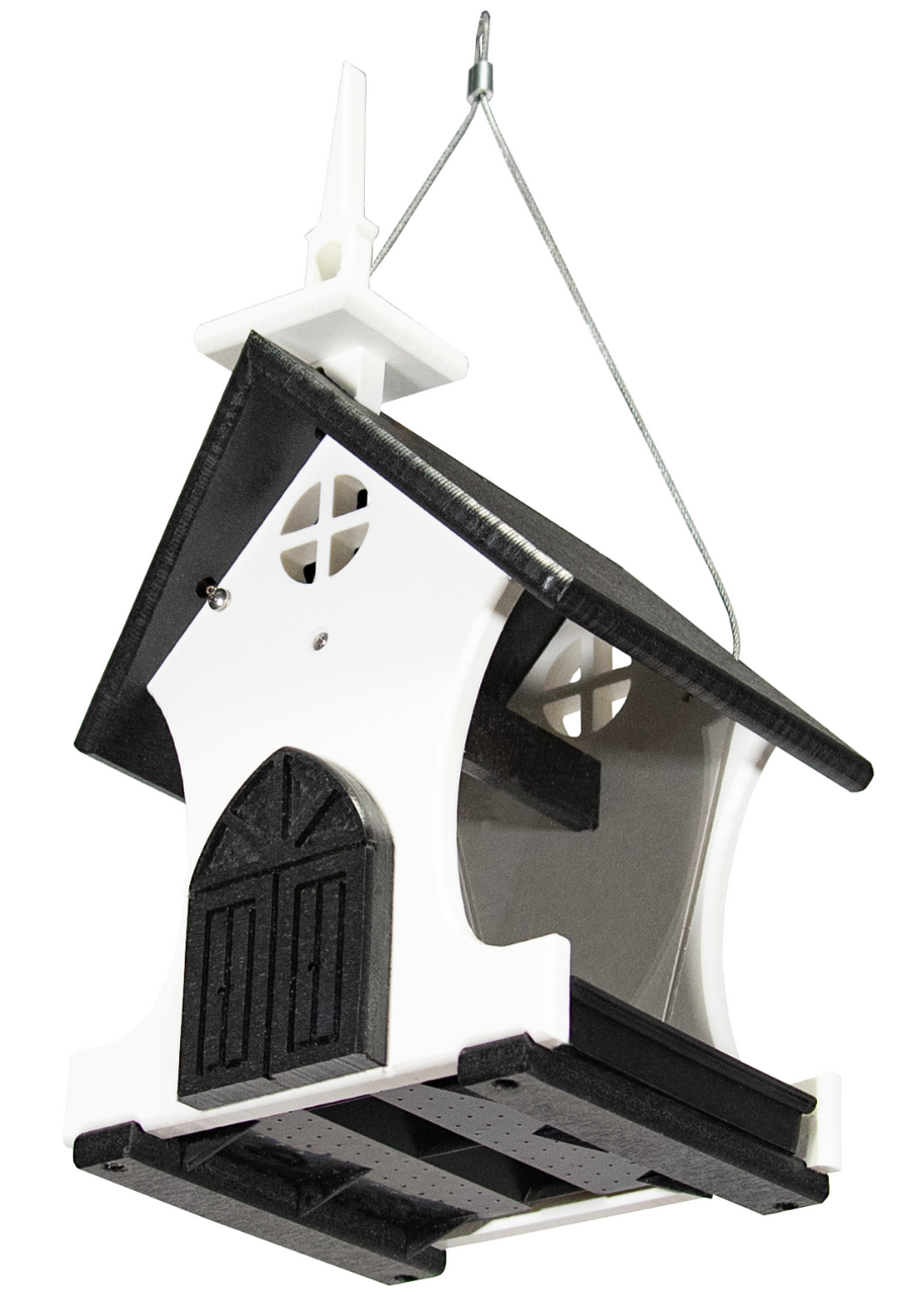 Plastic birdhouse designed as a white and black church with a steeple, cross window details, and a small door hanging against a white background