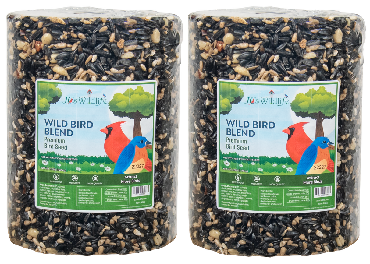 JCS Wildlife's photograph shows two cylindrical packages of Wild Bird Blend premium bird seed featuring black oil sunflower seeds, shelled peanuts, and a vibrant cardinal and bluebird illustration.