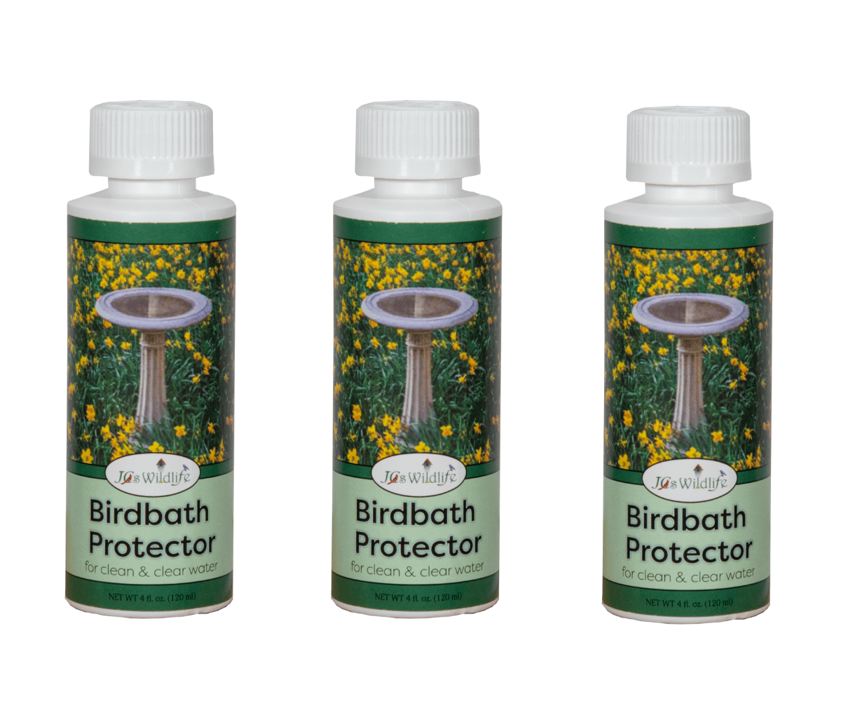 Product Photography: Three J&S Wildlife Birdbath Protector bottles show a stone birdbath nestled amongst vibrant yellow flowers and lush green foliage against a white background