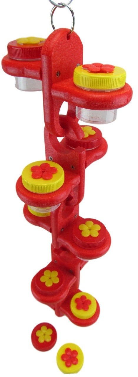 Plastic bird feeder toy with red and yellow flower-shaped lids clear containers and a hanging loop