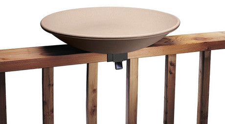 Product shot of a beige plastic bird bath attached to a light brown wooden deck railing with a dark grey metal clamp showing a simple design and easy installation