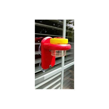 Nectar DOTS Window Hummingbird Feeder in yellow and red attached to a window, holding 1.25 oz of nectar in a large DOT with 100% recycled poly lumber holder