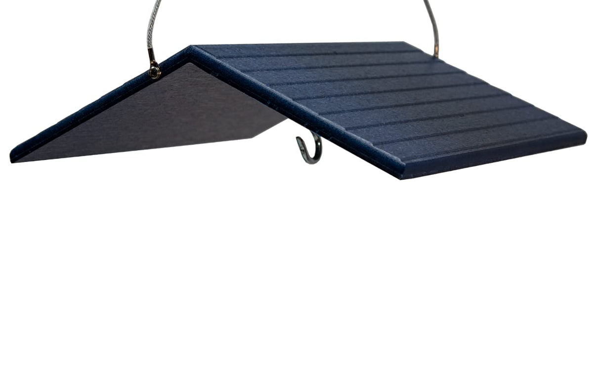 Close-up of a dark blue plastic bird feeder with a sloped roof and ribbed texture hanging from a metal hook and wire