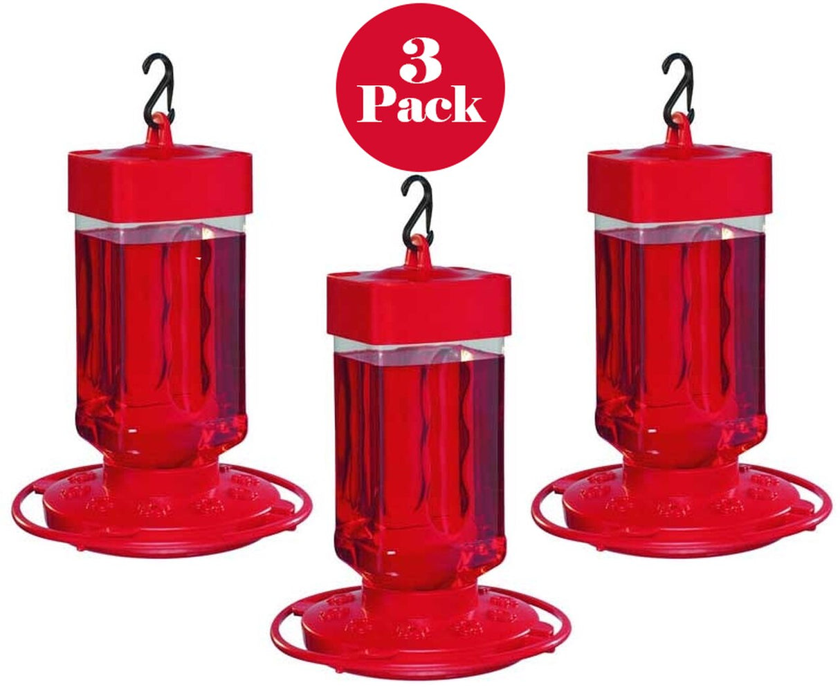 Three-pack of red plastic hummingbird feeders with clear reservoirs showing bright red nectar and black hanging hooks