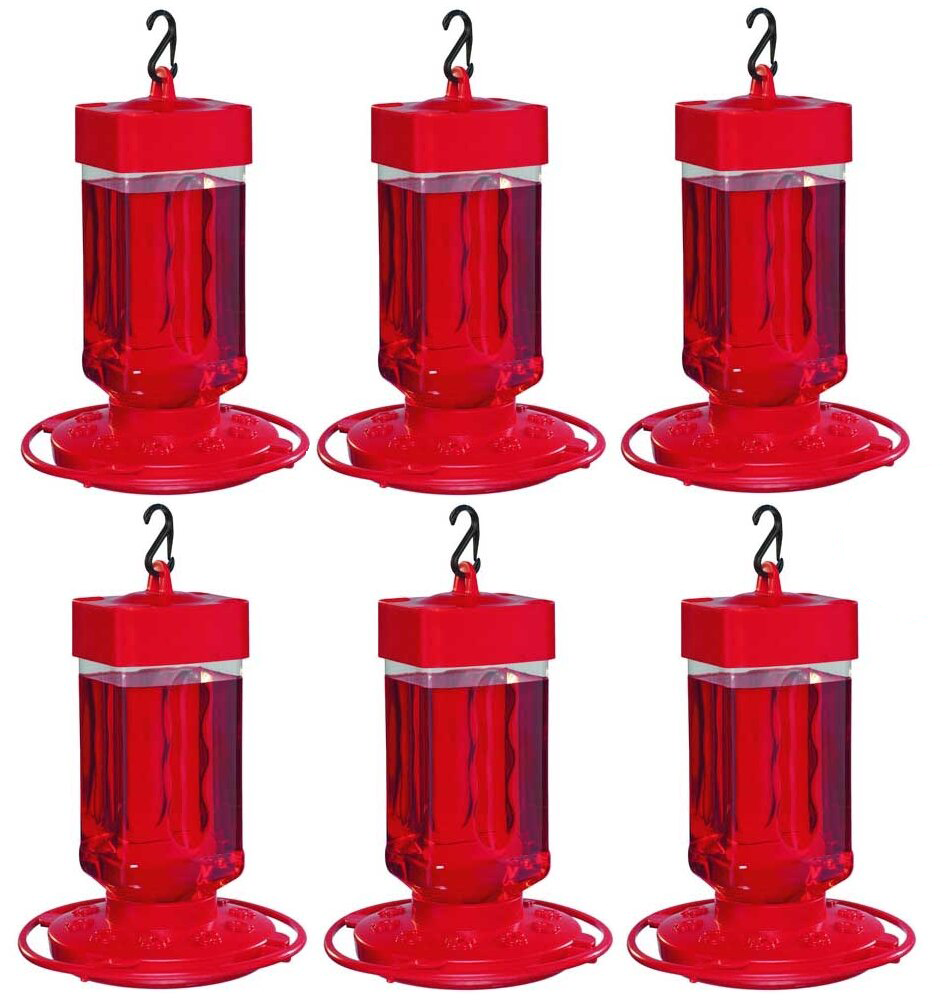 Six red plastic hummingbird feeders filled with red nectar on a white background.