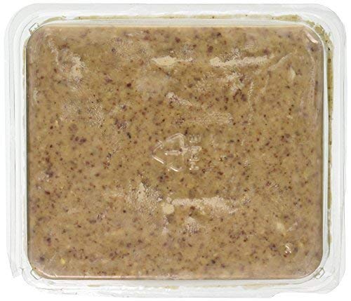Food product in clear plastic container showing a peanut butter like spread with flecks of brown and tan throughout