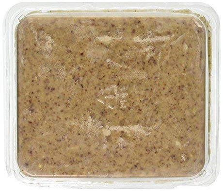 Food product in clear plastic container showing a peanut butter like spread with flecks of brown and tan throughout