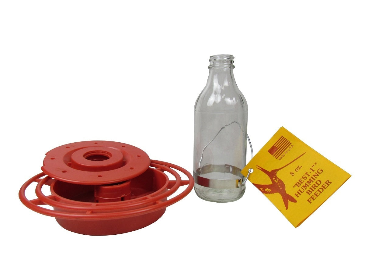 Product shot of Best-1 hummingbird feeder showing a red plastic base a clear glass bottle a yellow tag and a metallic band