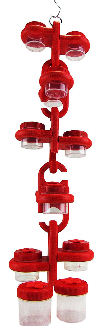 Plastic red hummingbird feeder with multiple clear containers hanging from a metal hook showing vibrant red plastic and clear see-through containers