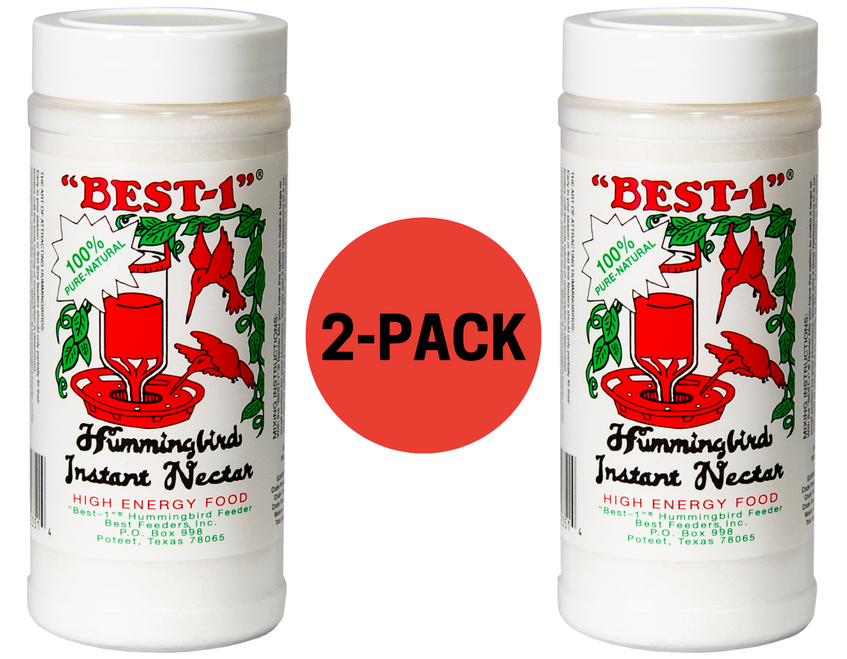 Product photography of a two-pack of Best-1 Hummingbird Instant Nectar by Best Feeders, Inc, featuring a vibrant red hummingbird feeder and lush green foliage against a white background, showcasing a 100% pure natural claim and  detailed product information