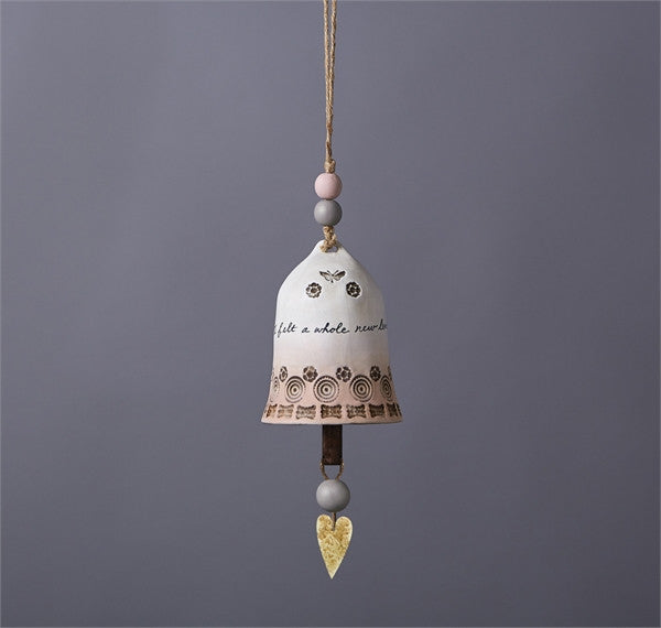 Ceramic bell charm by East of India features a pink and grey ombre design with embossed butterflies and floral details and a gold heart pendant