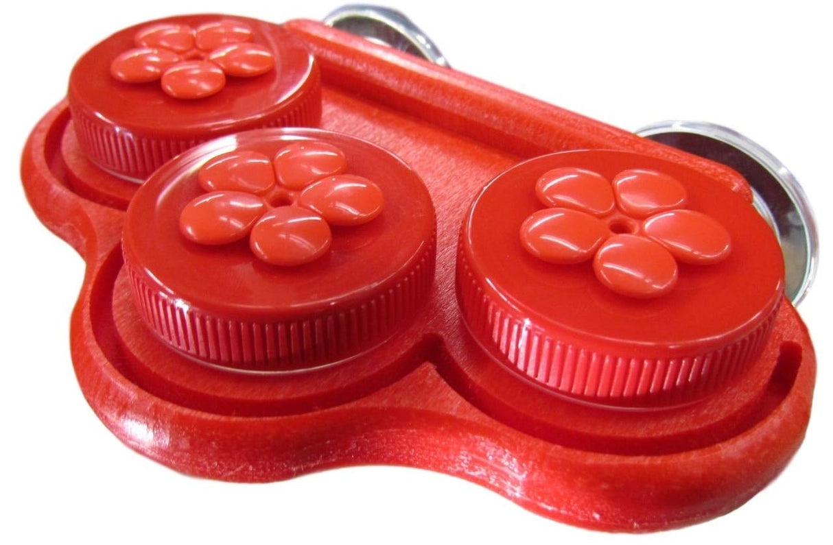 Plastic red three-container holder with flower-shaped tops and suction cups showing glossy, ribbed, and molded details