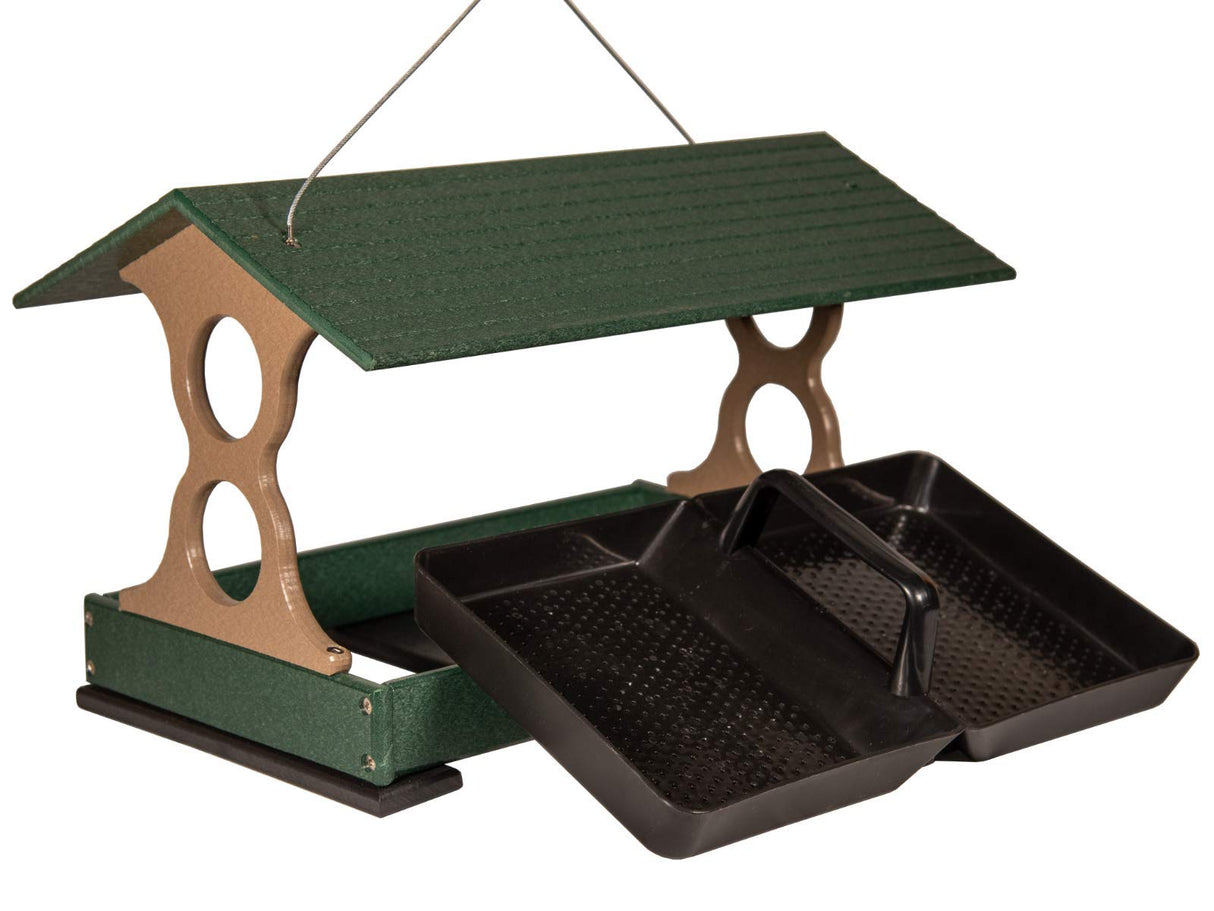 Plastic bird feeder with green roof tan accents and two black removable trays showing textured surfaces and a wire hanger