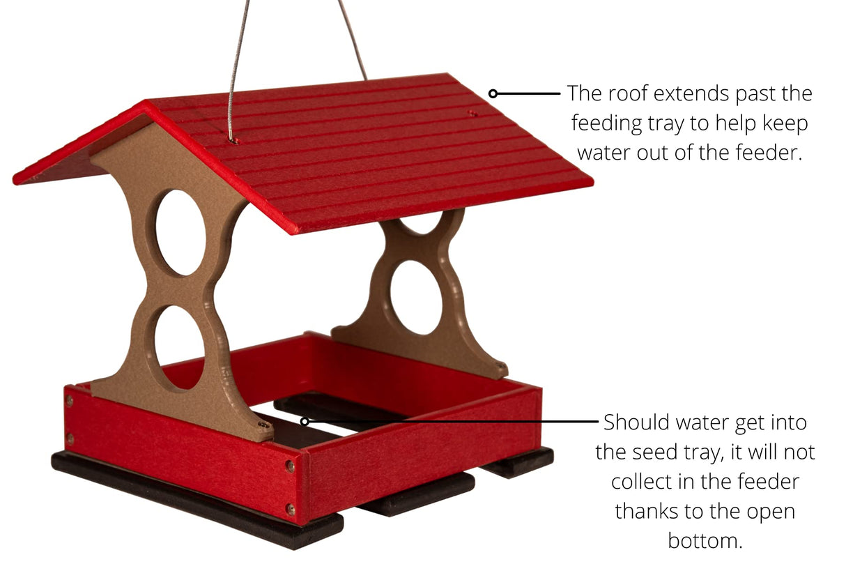 Product shot of a red and taupe plastic bird feeder with a protective overhang and open bottom against a white background