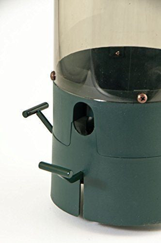 Close-up of a dark green plastic bird feeder with a clear plastic top featuring copper colored screws and two small metal levers for access.