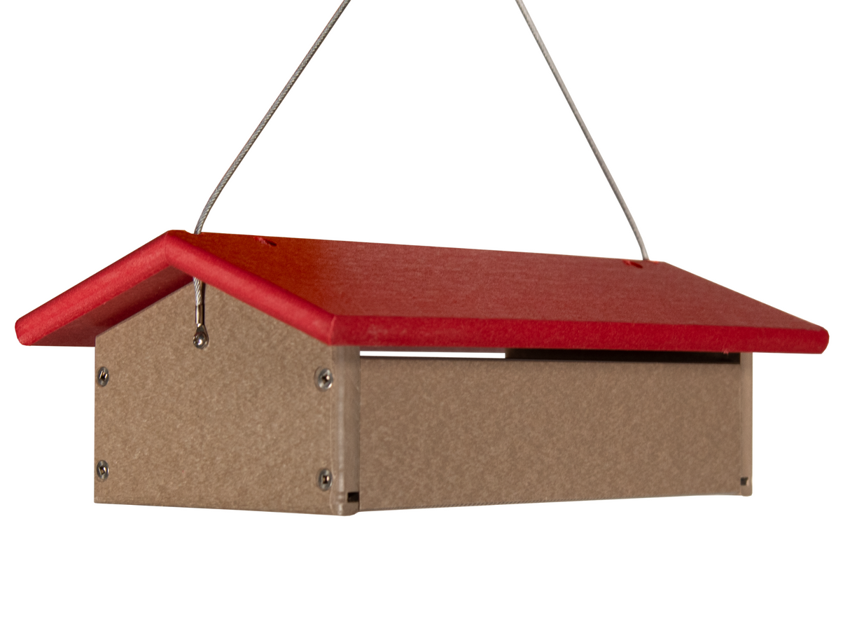 Recycled plastic bird feeder with a red roof and taupe body hanging from wire cables showing visible screws and a simple design