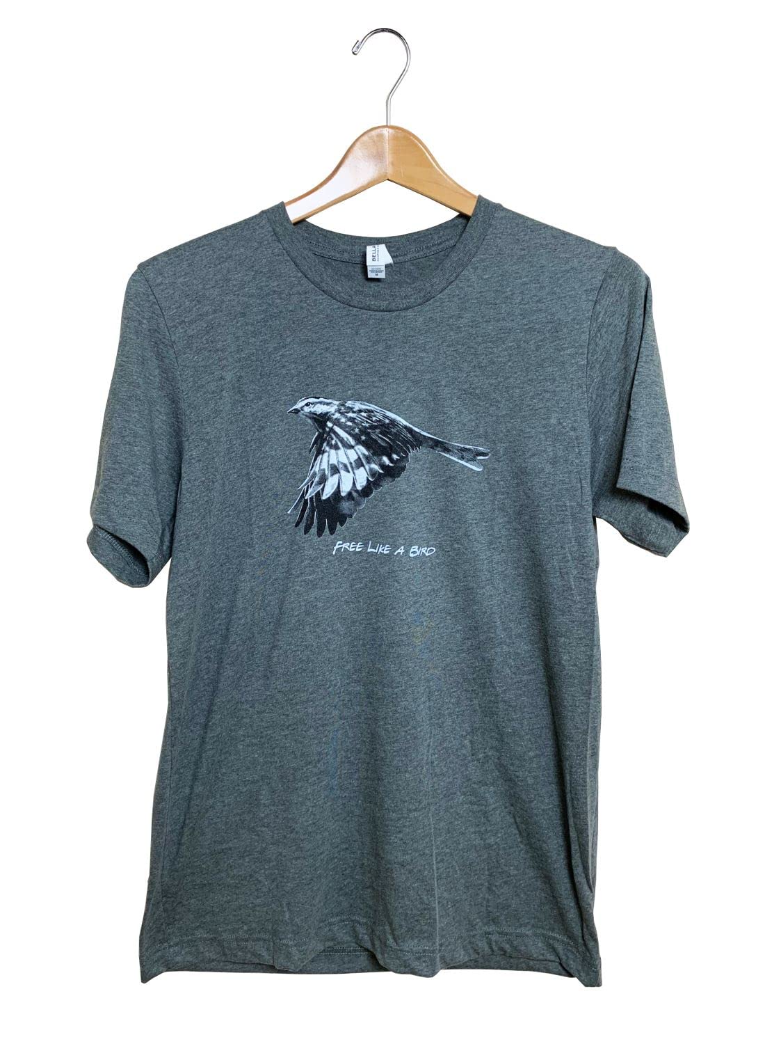 Gray t-shirt featuring a monochrome bird in flight design with the words Free Like a Bird the bird has striking black and white wing patterns on a heather gray tee