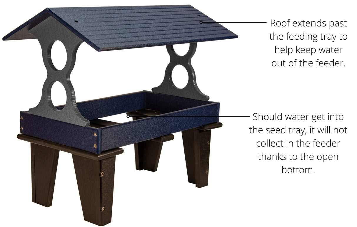 Plastic bird feeder with dark blue and gray textured plastic showing a sloped roof, two side access holes and sturdy black legs.