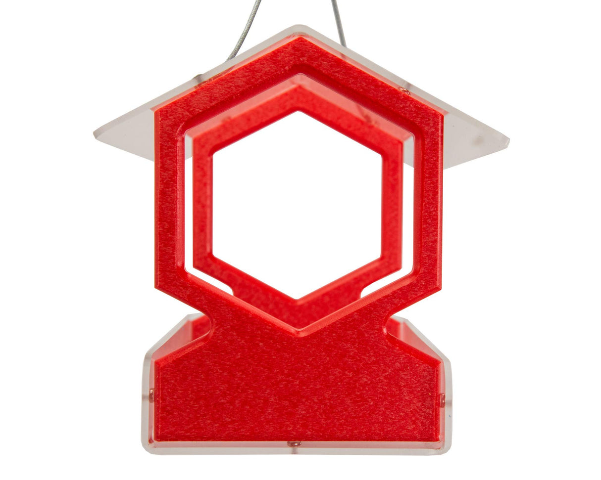 Plastic bird feeder, vibrant red color with a clear top and hexagonal openings, hanging design with textured surface