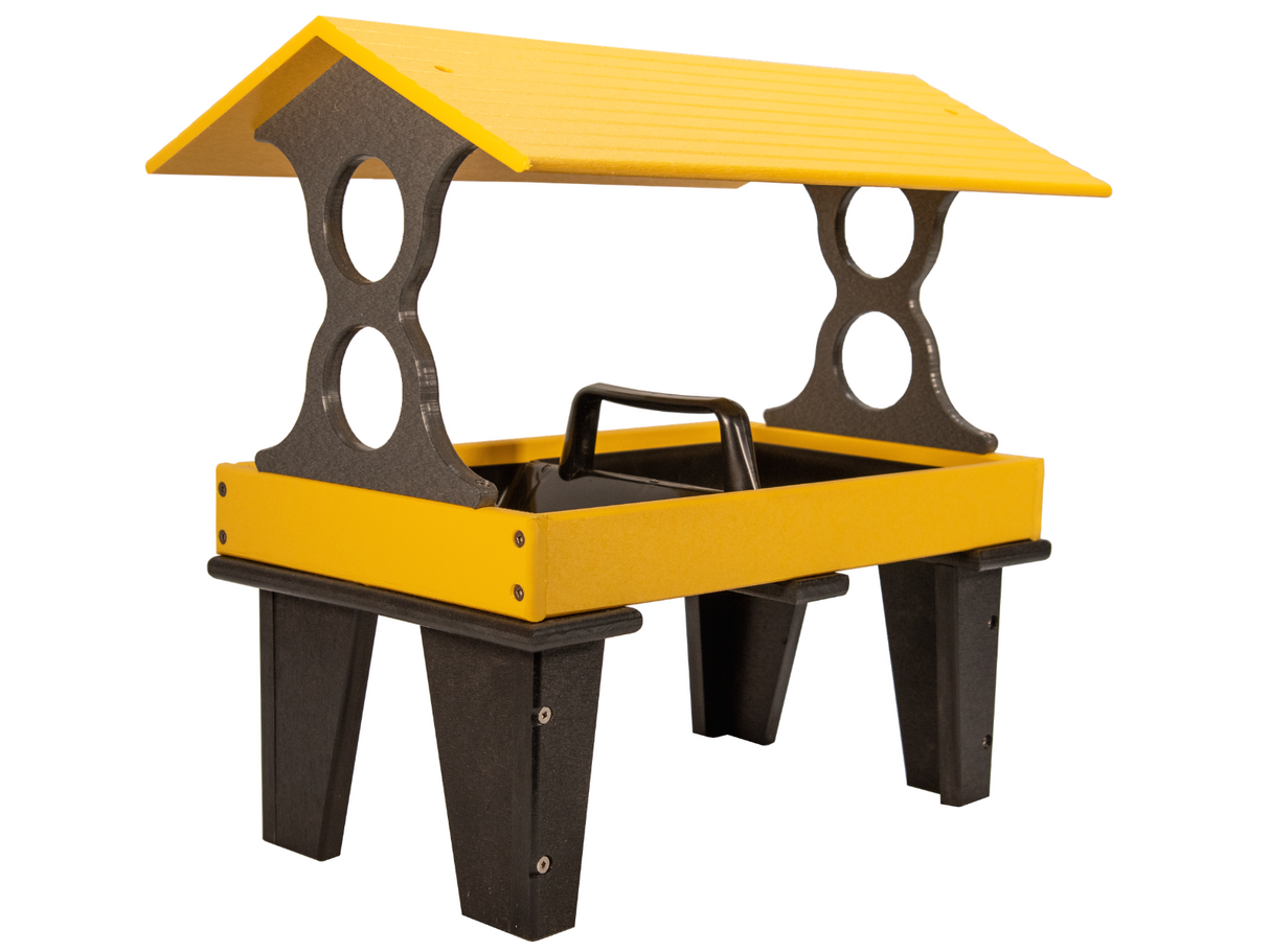 Plastic recycled lumber bird feeder with yellow tray and black supports featuring a gabled roof and two circular cutouts on either side of the feeder