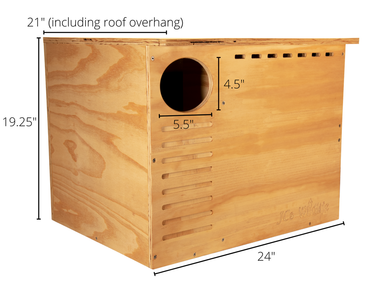 JCs Wildlife wooden birdhouse showing dimensions, a large entrance hole, ventilation slots, and a light brown wood finish