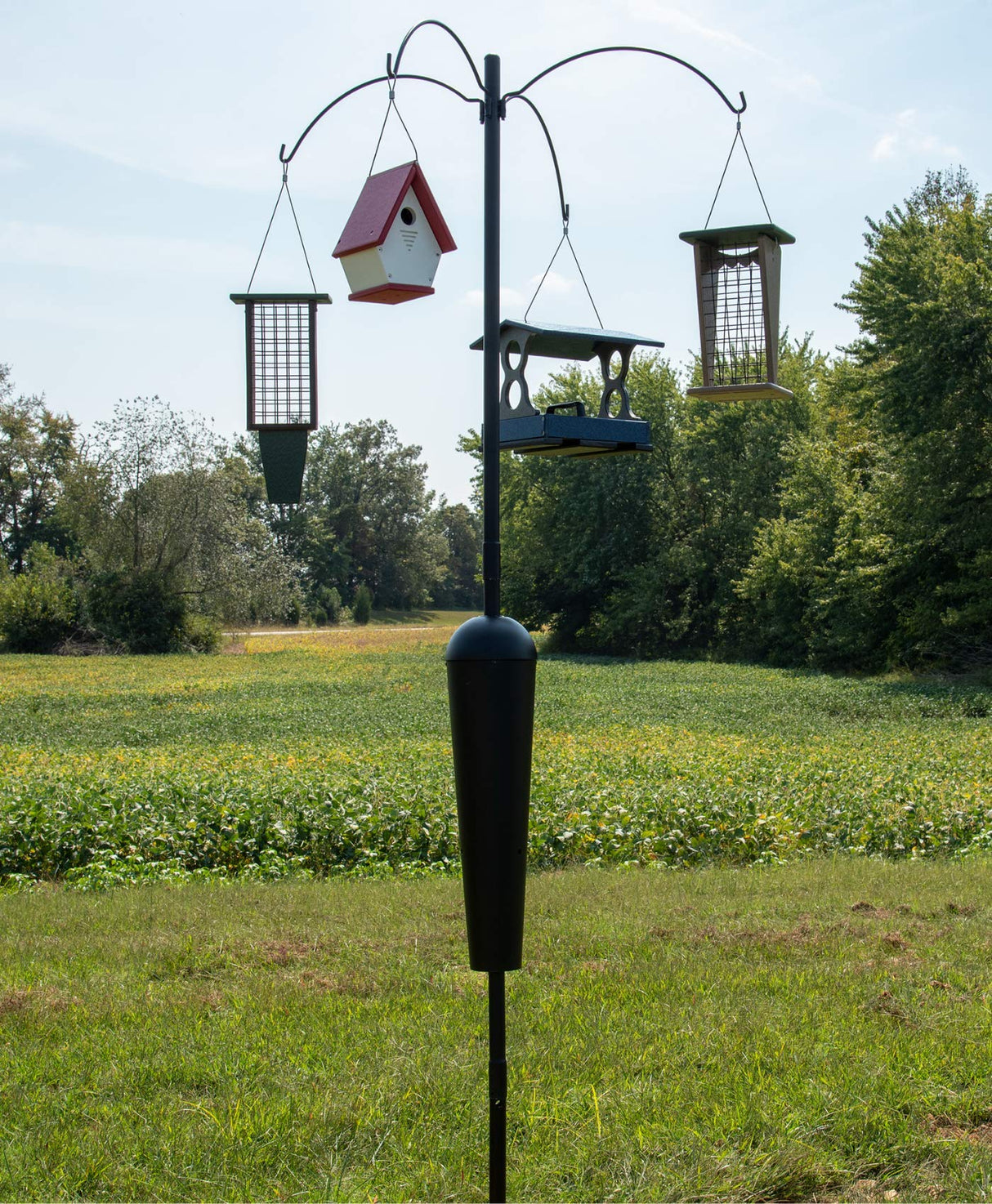 Squirrel Stopper Sequoia Squirrel Proof Pole System with 4 feeders in a green outdoor setting.