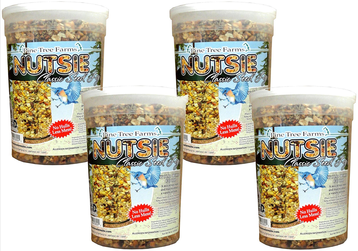 Pine Tree Farms Nutsie Classic Seed Log shows a colorful mix of nuts and seeds in clear plastic containers with a vibrant bluebird and a bird feeder.