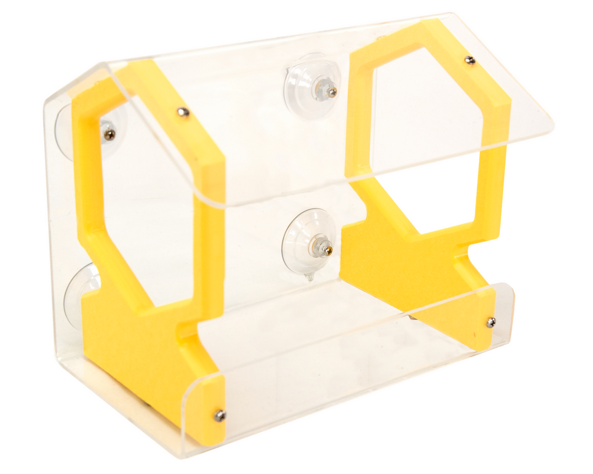 Product shot of an acrylic and yellow plastic bird feeder with suction cups attached to a window showing a clear and vibrant design with hexagonal cutouts and visible screws