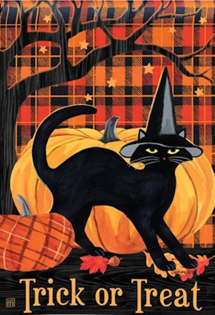 Jim Shore’s illustration a black cat wearing a witch’s hat sits amongst pumpkins against a red and black plaid background featuring a bare tree and autumn leaves