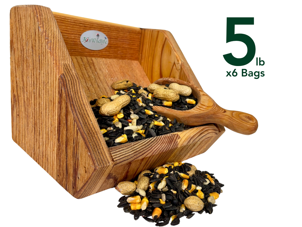 JOS Wildlife wooden bird feeder overflowing with black oil sunflower seeds peanuts and cracked corn in a rustic setting