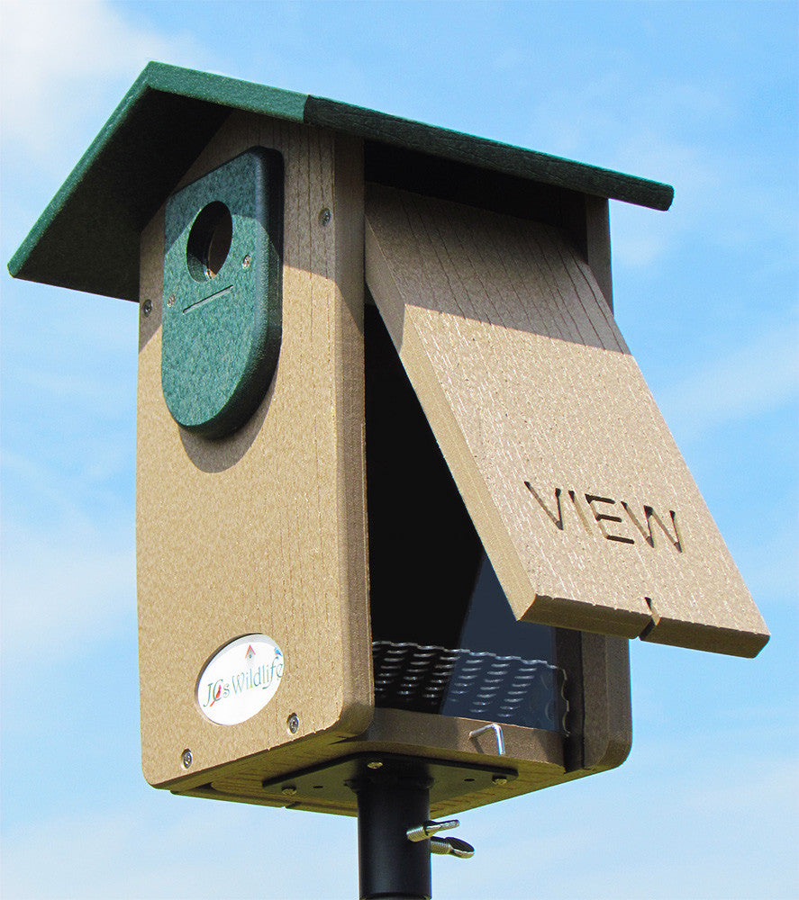 Jo's Wildlife recycled plastic birdhouse with a tan body green roof and viewing panel showing interior details against a bright blue sky