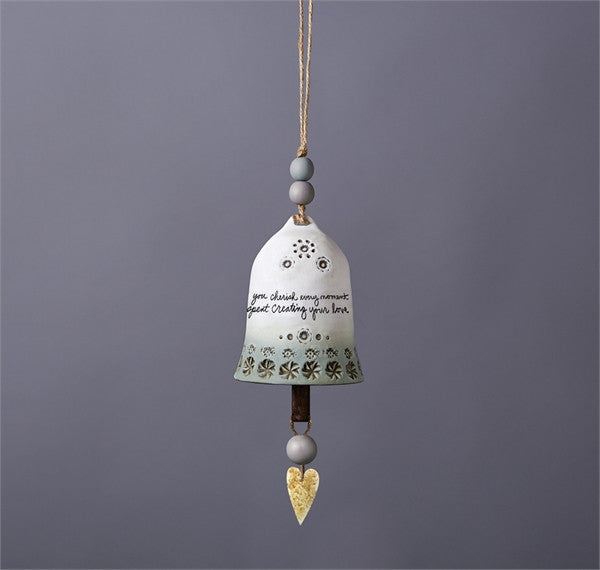 Ceramic bell by a unknown artist featuring a hand-painted sentiment  grey and white color scheme and small floral accents on a rustic hemp cord
