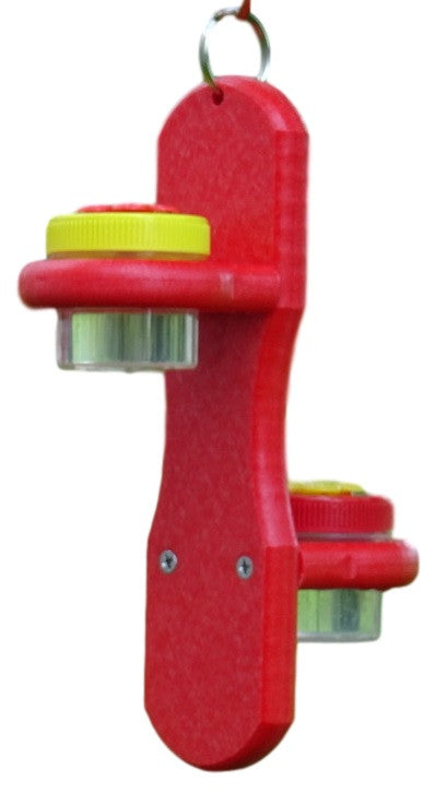 Plastic red hummingbird feeder with two clear reservoirs and bright yellow lids featuring a hanging ring and two small screws visible on the side