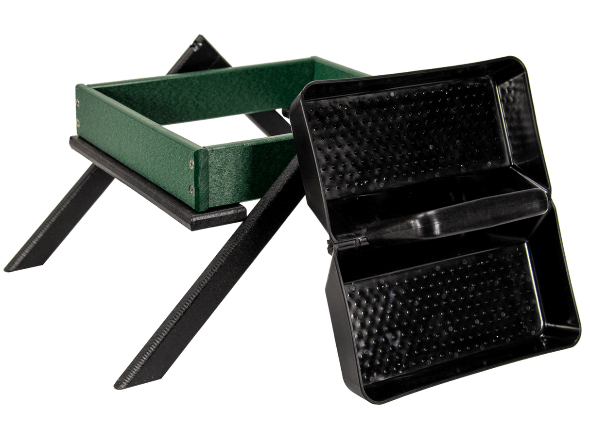 Product shot of a green and black plastic bird feeder with textured trays and a sturdy X-shaped base showing a close-up view of its details