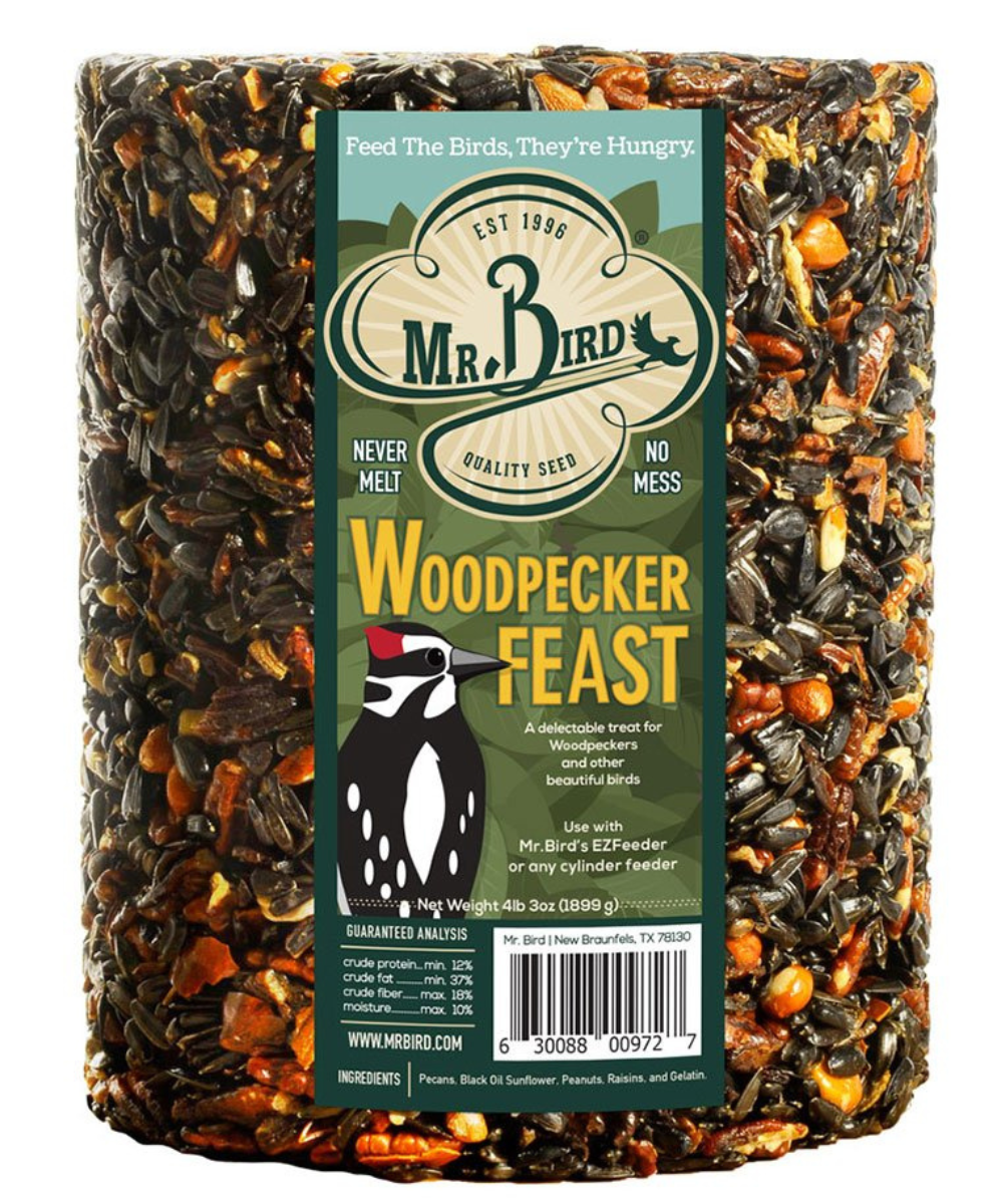 Mr. Bird's Woodpecker Feast birdseed cylinder features pecans, black oil sunflower seeds, and raisins against a green and brown label with a woodpecker illustration