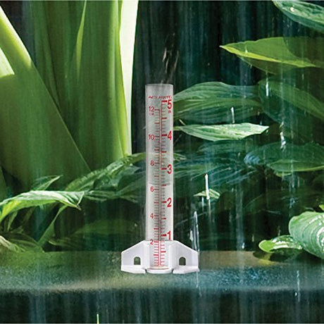 AcuRite Glass Rain Gauge measuring rainfall in garden with green foliage in the background