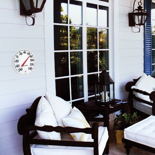 AcuRite 12.5" Indoor and Outdoor Thermometer on patio wall, displaying temperature in Fahrenheit, visible from a distance