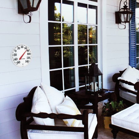 AcuRite 12.5" Indoor and Outdoor Thermometer on patio wall, displaying temperature in Fahrenheit, visible from a distance
