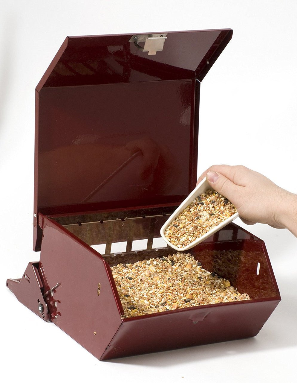 Person filling Audubon Bird's Choice squirrel proof bird feeder with seed