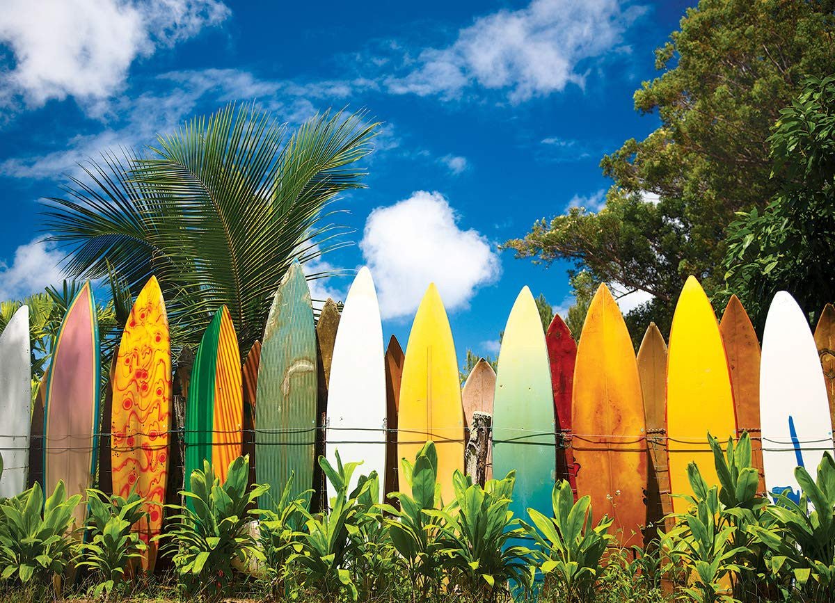 Colorful surfboards lined up against a vibrant blue sky on a sandy beach in Hawaii.