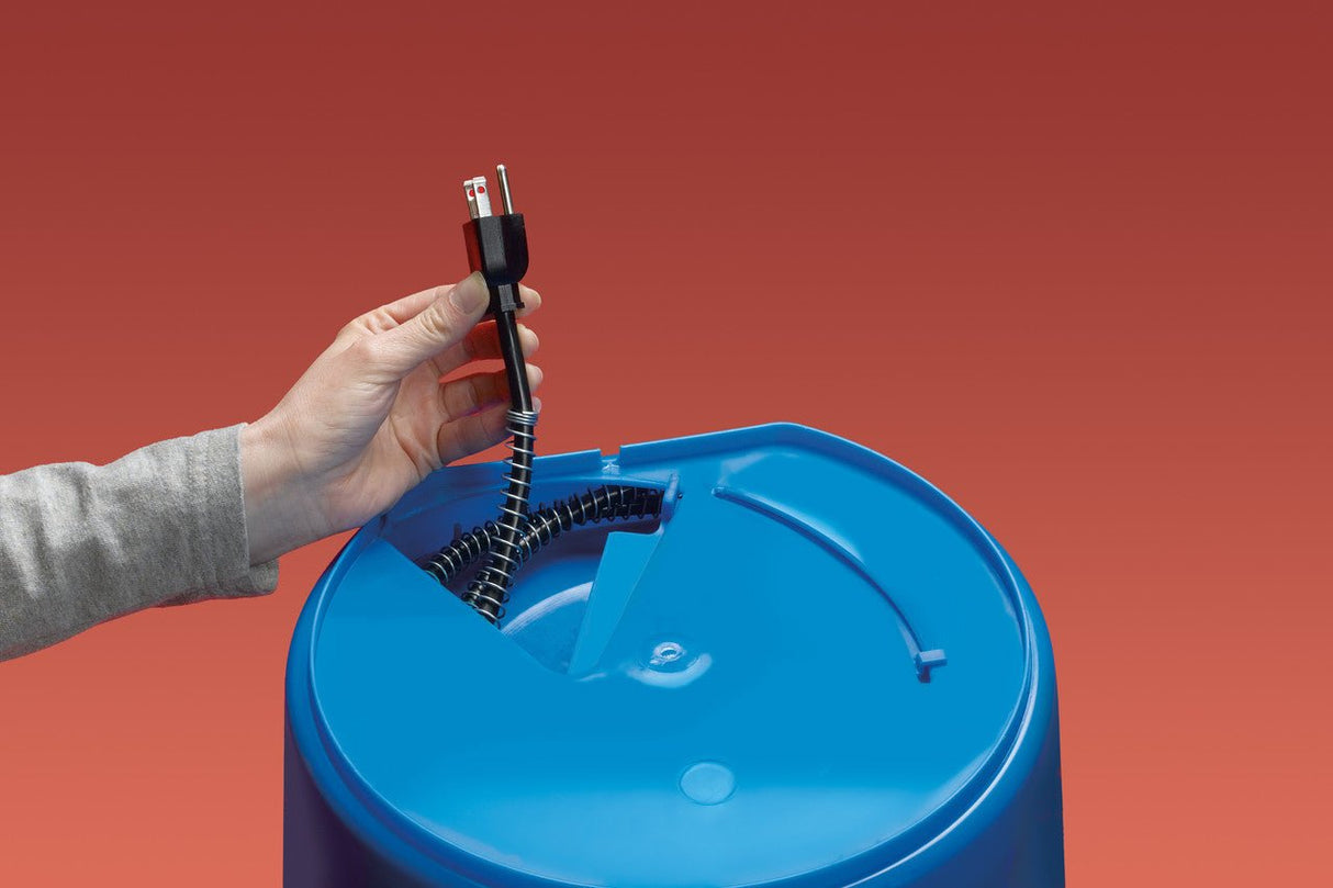 Hand holding the power cord of a blue API Heated 20 qt. Flat Back Bucket against a red background