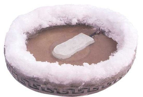 Unknown artist, photograph of a frozen bird bath with a Greek key design, featuring a light grey rectangular ice block in brown water surrounded by a thick layer of frost and showcasing a unique textured surface