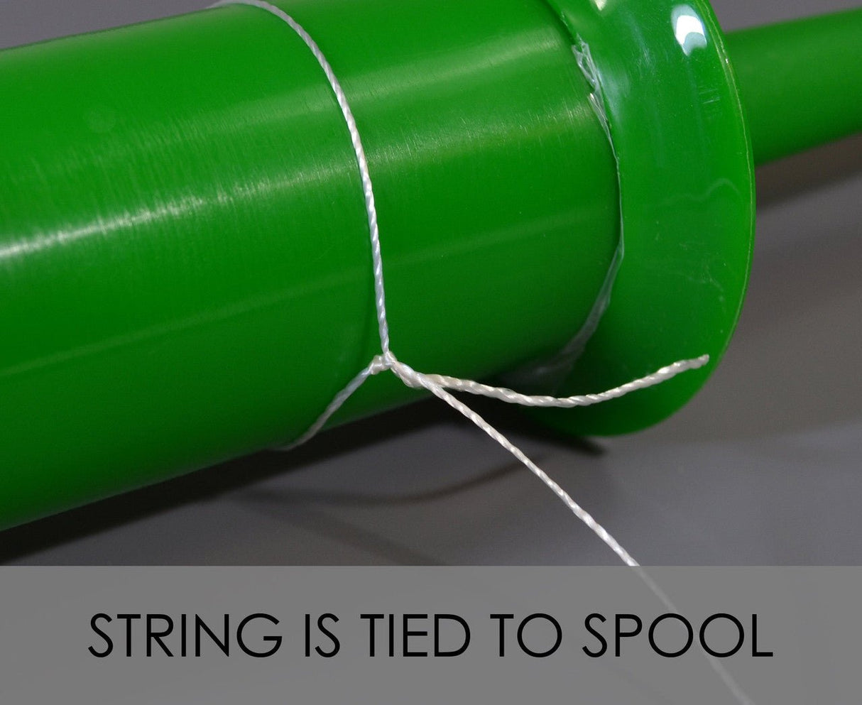 Close-up of a green plastic spool with kite string tied around it for the In The Breeze 30 LB twisted kite line.